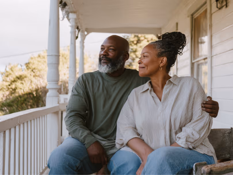 A couple relaxing together on their front porch.